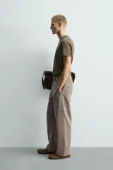 Camiseta de algodón color verde oliva, corte regular fit, con cuello redondo y manga corta. Presenta un pequeño corazón bordado en la manga.