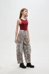 Pantalon tipo jean de corte barrel y tiro bajo, con estampado animal print de leopardo en tonos marrones y blancos.