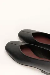 Chatas planas de cuero color plateado metálico, con punta cuadrada y un pequeño tacón bajo de madera.