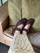 Zapatos tipo Mary Jane con punta cuadrada, confeccionados en cuero con estampado de vaca (animal print) y tira ajustable con hebilla metálica en color marrón.