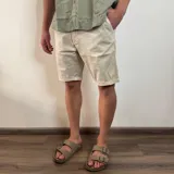 Bermuda de gabardina color marrón claro, corte recto, con bolsillos laterales y traseros.