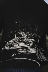 Buzo de punto acanalado en color negro, con diseño gráfico estampado en blanco en la espalda que representa una vista aérea de un estadio. Presenta mangas largas y un corte holgado.