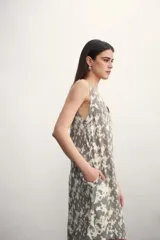 Vestido corto con estampado abstracto en tonos grises y blancos, escote en V y sin mangas.