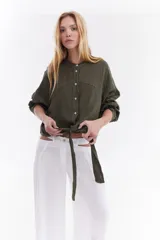 Camisa blanca de lino italiano, de corte holgado, mangas largas abullonadas, cuello mao y cierre frontal con botones, con diseño para anudar en la cintura.