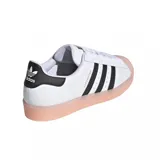 Zapatillas Adidas Superstar blancas con las tres tiras laterales en negro, contrafuerte negro con logo blanco y puntera y suela color salmón.