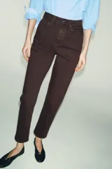 Jeans de tiro alto con corte mom fit, cinco bolsillos y cierre frontal con cremallera y botón.