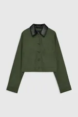 Chaqueta Yuma de inspiración utilitaria, color verde militar, confeccionada en algodón estructurado con acabado suave y desgastado. Presenta una silueta relajada, bolsillos de parche frontales y cierre de botonadura central con botones en tono gris plomo.