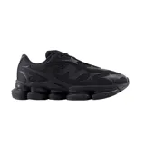 Championes New Balance modelo 2000, color negro monocromático. Presentan un diseño técnico con base de malla transpirable y superposiciones sintéticas con formas orgánicas. Incluyen el logo N en el lateral y una suela robusta con tecnología de amortiguación visible.