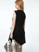 Vestido corto color beige, cruzado, sin mangas y ajustable con lazo lateral.