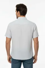 Camisa negra de manga corta, con cuello clásico, cierre frontal con botones y bolsillo ojal en el pecho.