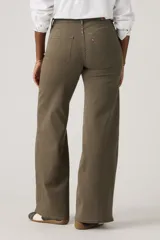 Pantalón de jean estilo wide leg en color verde oliva, con costuras verticales frontales que recorren el largo de las piernas. Presenta un diseño de tiro medio con cierre de botón y cremallera, y bolsillos laterales.