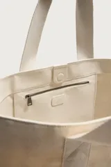 Bolso tipo shopper de tejido de algodón color beige, con doble asa de mano y cierre magnético.