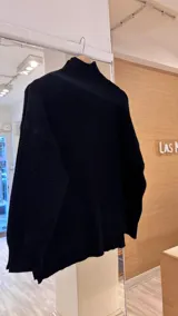 Sweater tejido de punto color beige, con cuello alto y trama lineal.