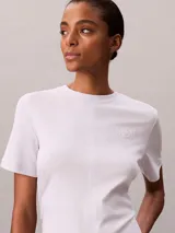 Remera Calvin Klein de manga corta y cuello redondo, color blanco, confeccionada en algodón pima. Presenta costuras verticales en el frente y un sutil logo script de la marca bordado en el pecho.