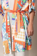 Kimono italiano de satén estampado con motivos geométricos y florales en tonos rojo, azul, naranja y dorado. Incluye lazo de ajuste en la cintura.