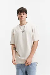 Remera de manga corta con calce oversize, color beige, con estampado floral y tipográfico en la espalda.