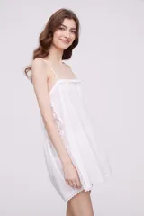 Vestido corto color marfil con breteles finos, escote recto y detalle de puntilla en los laterales y ruedo.