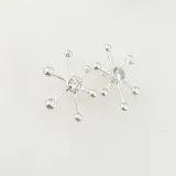 Aros plateados con forma de estrella de mar con un cristal en el centro y bolitas en las puntas.