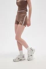 Short tipo biker de poliamida, color marrón camel, con diseño ajustado al cuerpo, cintura alta y detalle de línea lateral blanca.