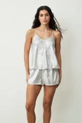 Conjunto de pijama plateado brillante, compuesto por un top de tirantes con escote en V y shorts sueltos.