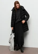 Campera acolchada tipo puffer de corte midi, color negro, con capucha, cierre frontal de cremallera doble, bolsillos laterales y puños elásticos.