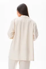 Blazer color crudo de corte elegante, con cierre frontal, confeccionado en mezcla de algodón.