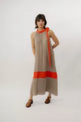 Vestido largo color marrón con detalles en tono marfil, escote halter y lazo largo en el cuello.