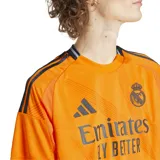 Camiseta de fútbol Adidas de la segunda equipación del Real Madrid, temporada 24/25, color naranja con detalles en negro. Incluye logo de Adidas, escudo del club y sponsor Emirates Fly Better en el frente.
