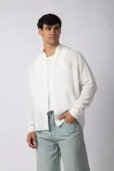 Camisa de manga larga confeccionada en tejido de lino con textura, de corte holgado y diseño versátil con cierre frontal de botones.