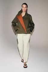 Pantalón de tiro medio confeccionado en mezcla de algodón, con diseño cruzado frontal y cierre de botones. Presenta cintura con trabillas, bolsillos laterales ocultos y detalle de bolsillo con solapa y botón en el delantero.