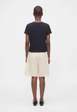 Remera blanca de algodón con corte boxy, ligeramente oversize, de líneas rectas y mangas cortas, con cuello redondo acanalado.