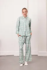 Conjunto de pijama de dos piezas, color verde menta con estampado de cuadros irregulares en blanco. Incluye camisa de manga larga con botones y pantalón largo con cintura elástica.