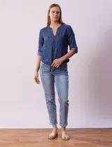 Blusa celeste de tencel, marca Alex & Parker. Cuello a la base, escote en V y abertura central con botones. Delantera con bolsillos. Largo de manga regulable con presilla y botón. Terminación de ruedo con nudo.