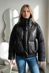 Campera puffer de ecocuero negro con cuello alto, cierre frontal oculto y puños y ruedo de tejido elástico acanalado.