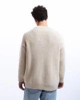 Sweater unisex color crema de lana merino, con cuello redondo y corte holgado.