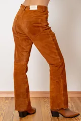 Pantalón de cuero ovino italiano color crema, de corte recto con tajos laterales en el ruedo.