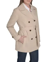 Campera corta tipo trench de Tommy Hilfiger, color beige, con diseño cruzado de doble botonadura, cuello con solapa, cinturón ajustable en la cintura y puños con trabillas.