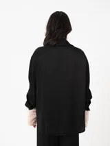 Camisa color ladrillo de corte amplio y mangas largas, con cuello camisero y cierre frontal con botones.