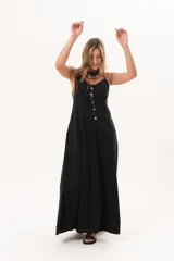 Vestido largo de denim fino y liviano color negro, de breteles finos, escote delicado, silueta entallada arriba y falda amplia con bolsillos laterales.