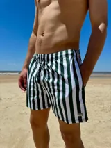 Short de baño con diseño de rayas verticales en color verde oscuro y blanco, con cintura elástica, cordón ajustable y detalle de etiqueta metálica en el ruedo.