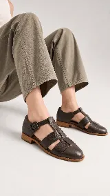 Sandalias tipo cangrejera de cuero color marrón, con diseño de tiras cruzadas y textura en la parte frontal. Cuentan con pulsera al tobillo con hebilla metálica y taco bajo.