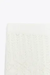 Shorts blancos de tejido de punto con calados geométricos y cintura elástica.