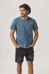 Remera de manga corta color azul grisáceo, con cuello redondo y un pequeño texto bordado en negro en el pecho.