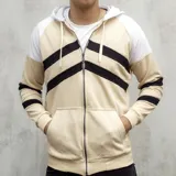 Campera con capucha color beige y mangas blancas, con cierre frontal y bolsillos tipo canguro. Presenta franjas horizontales negras en el pecho y las mangas.