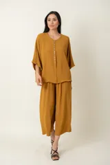 Conjunto de dos piezas compuesto por una blusa de manga corta con cierre frontal de botones y un pantalón ancho de corte holgado con cintura elástica.