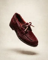 Mocasín de cuero con textura de pelo natural en color granate, con cordones de cuero y detalle de lazo frontal.