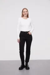 Pantalon jean de corte flare, tiro medio, con ruedo desflecado y cierre frontal con botón y cremallera.