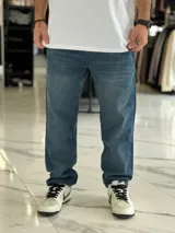 Pantalón de jean azul con lavado clásico, de corte holgado y estilo oversize.