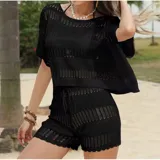 Conjunto de dos piezas tejido en punto calado color negro, compuesto por una blusa de manga corta con cuello redondo y un short con cintura elástica y cordón ajustable.