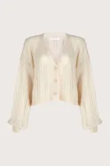 Cardigan de punto color marfil con cuello en V, cierre frontal de botones y mangas largas abullonadas. Presenta un diseño de tejido con textura vertical y corte corto.